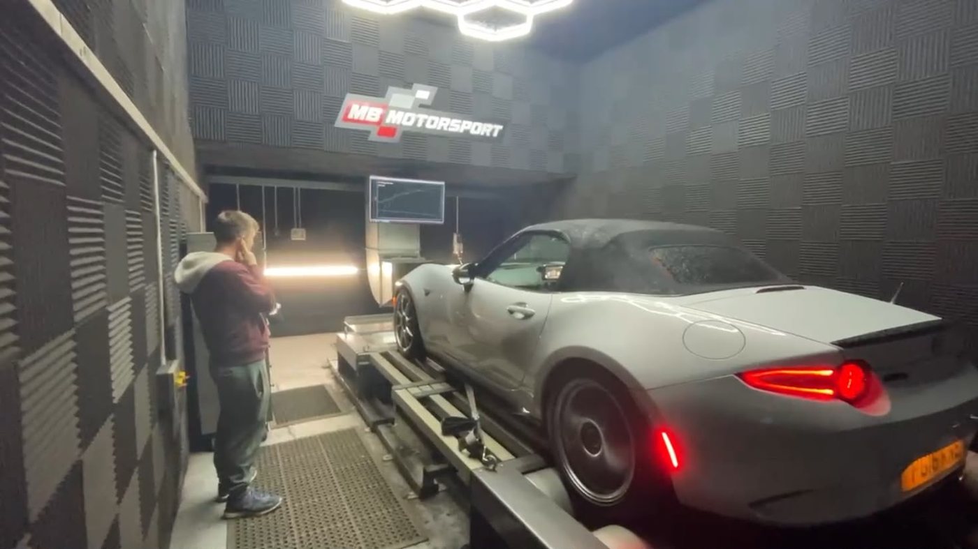 A Mazda MX-5 strapped to a rolling road in a dyno cell
